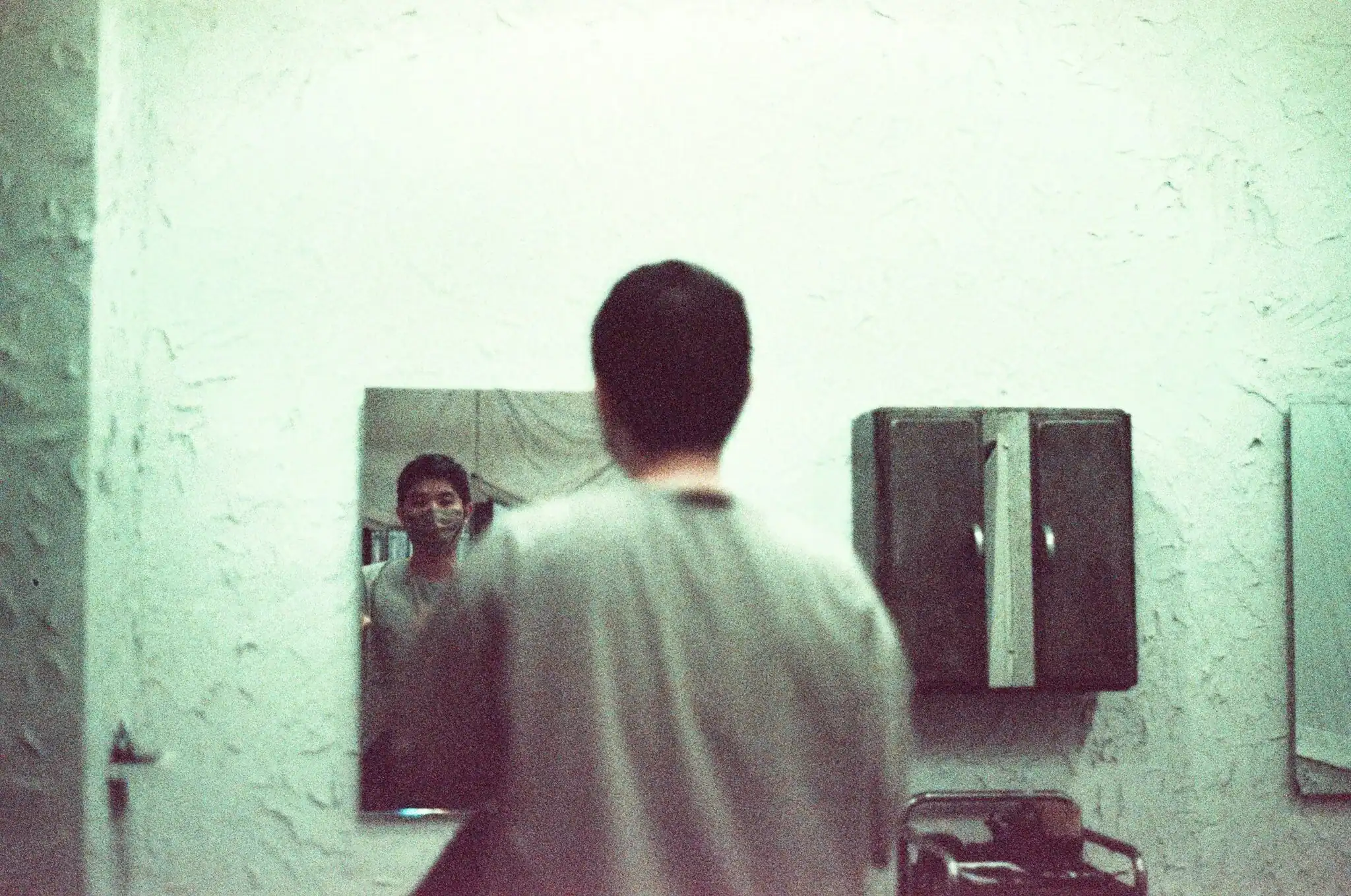 Man standing in front of a mirror in quiet reflection