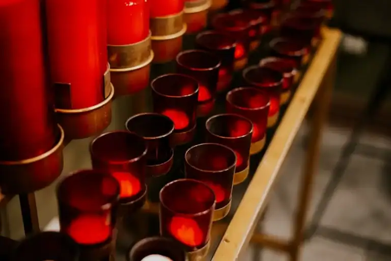 Row of red votive candles glowing in a quiet church space